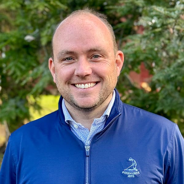Rob Durnin wearing a blue athletic shirt over a dress shirt outside